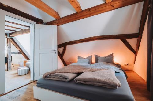 a bedroom with a bed in a room with wooden ceilings at Das Alte Pfarrhaus Galerie in Gleisweiler
