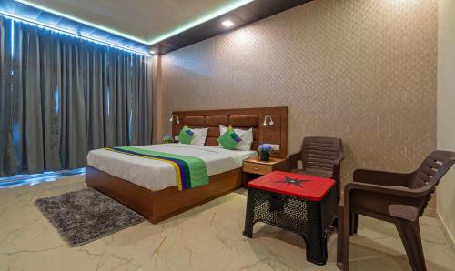 Un dormitorio con una cama y una mesa y sillas. en Treebo Heaven Grand Ayodhya, en Ayodhya