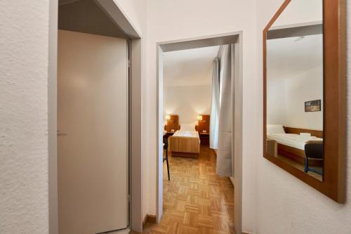a hallway of a hotel room with two beds and a mirror at Monteurzimmer für bis zu 26 Personen in Straubing low budget mit Gemeinschaftsküche NEU in Straubing