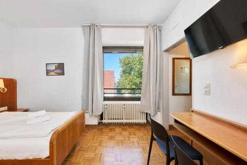 a room with a bed and a desk and a window at Monteurzimmer für bis zu 26 Personen in Straubing low budget mit Gemeinschaftsküche NEU in Straubing