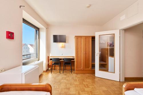 a hotel room with a desk and a window at Monteurzimmer für bis zu 26 Personen in Straubing low budget mit Gemeinschaftsküche NEU in Straubing