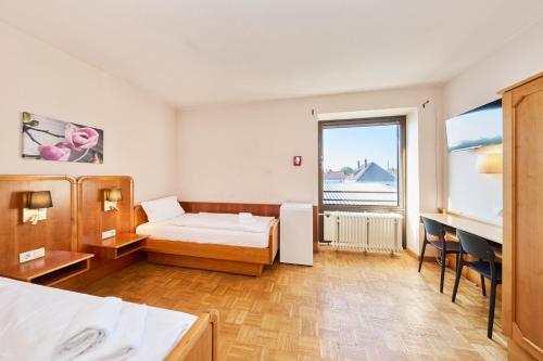 a bedroom with a bed and a desk and a window at Monteurzimmer für bis zu 26 Personen in Straubing low budget mit Gemeinschaftsküche NEU in Straubing