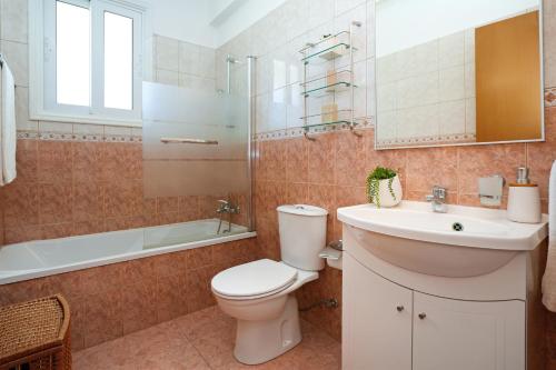 Un baño con inodoro, lavabo y bañera. en Villa Celine, en Protaras