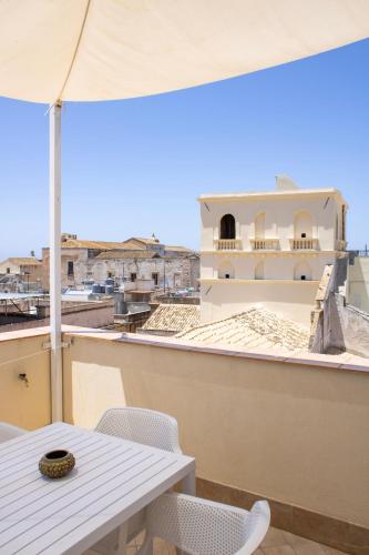 a white table and chairs on a balcony with a view at BADIA NUOVA Apart Hotel in Trapani