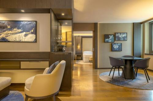 a living room with a table and chairs at Sheraton Grand Tbilisi Metechi Palace in Tbilisi City