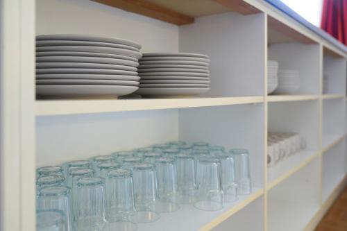 a cabinet filled with plates and bowls and dishes at Monteurzimmer für bis zu 26 Personen in Straubing low budget mit Gemeinschaftsküche NEU in Straubing