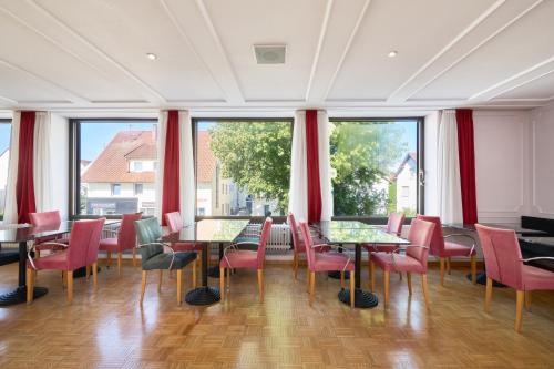 a restaurant with tables and chairs and large windows at Monteurzimmer für bis zu 26 Personen in Straubing low budget mit Gemeinschaftsküche NEU in Straubing
