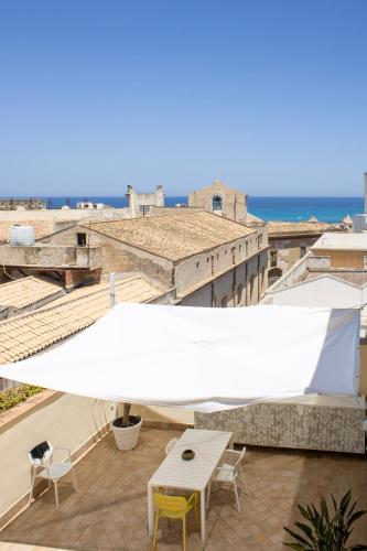 a table and chairs on a balcony with a view of the ocean at BADIA NUOVA Apart Hotel in Trapani
