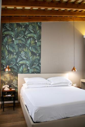 a bedroom with a white bed with a tropical wallpaper at BADIA NUOVA Apart Hotel in Trapani