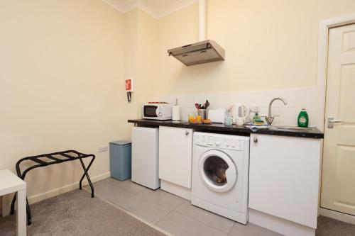 a kitchen with a washing machine and a sink at Chic Bath Flat for Couples with Free Parking! in Bath