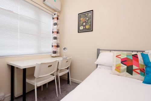 a bedroom with a desk and a bed and a table at Chic Bath Flat for Couples with Free Parking! in Bath