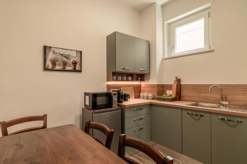 a kitchen with a table and a sink and a microwave at The Olive Suite in Cerbaia