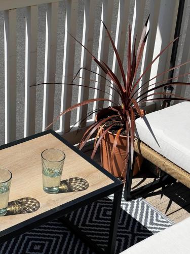 a table with two glasses and a potted plant at 43 Harbour View in Poole