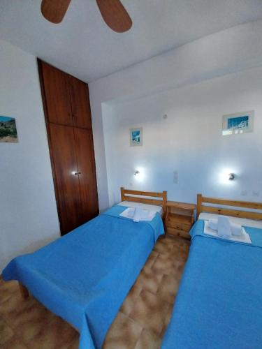 two beds in a bedroom with blue sheets at Ilios Kalamaki in Kalamaki Heraklion
