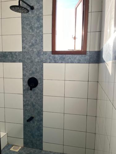 a bathroom with a shower with a window at Almond 7 in Gazi