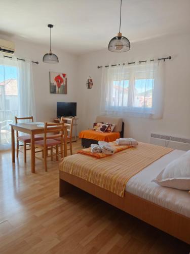a bedroom with two beds and a table and a dining room at Apartments Lans in Vodice