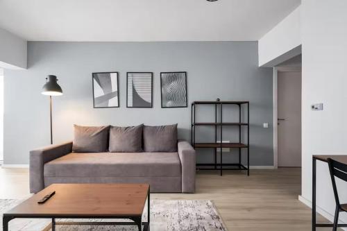a living room with a couch and a table at Green Heaven Apartment 2106 - Underground Parking & Self Check-in in Bucharest