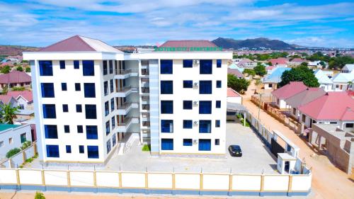 an overhead view of a white building with blue windows at Eastern City Apartments in Dodoma