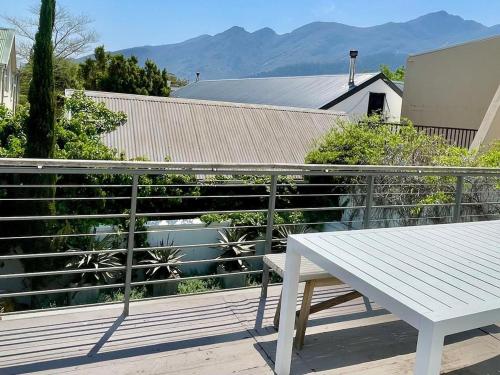 un banco blanco sentado en la parte superior de un balcón en Franschhoek Gem on Van Wijk, en Franschhoek