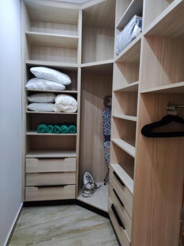 a walk in closet with wooden cabinets and shelves at Villa les 3 palmiers in Houmt Souk
