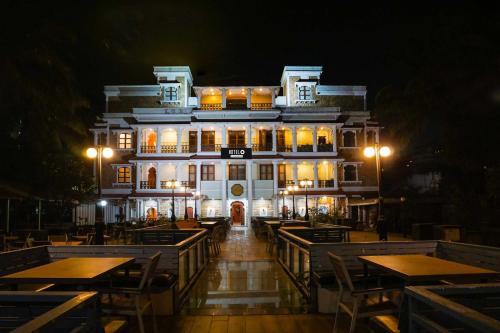 a building with tables in front of it at night at Collection O Baner Road Pune formerly Hotel Rajwada in Dāpuri