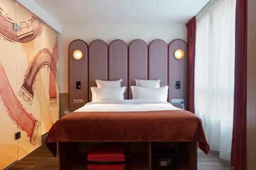 a bedroom with a large bed with a red headboard at lyf Gambetta Paris in Paris