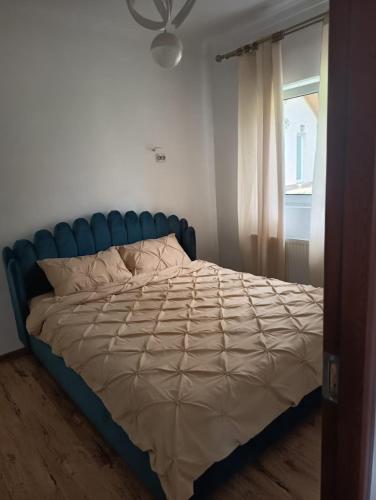 a bed with a blue headboard in a bedroom at Garden Chalet in Câmpulung