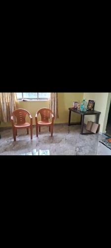 two chairs and a table in a room at Palghar Villa in Boisar