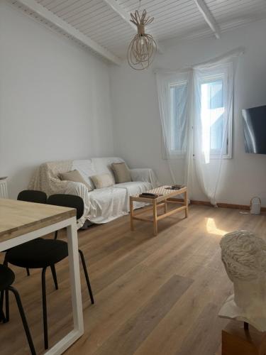a white living room with a couch and a table at Sea You Soon & Spa 1 in Methana