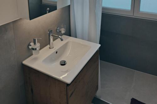 a bathroom with a white sink and a shower at Ferienwohnung in der Natur in Davos