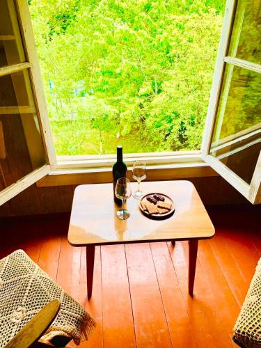 a table with a bottle of wine and two glasses at Villa Bubi in Tbisi