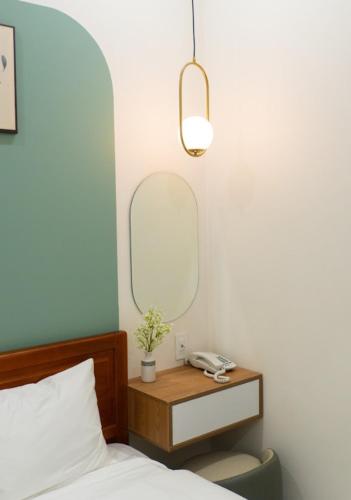 a bedroom with a bed and a table with a mirror at Soha Hotel Cần Thơ in Cái Răng