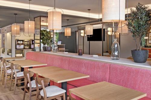 a restaurant with wooden tables and chairs and lights at B&B HOTEL Barcelona Mollet Porta de Gallecs in Mollet del Vallès