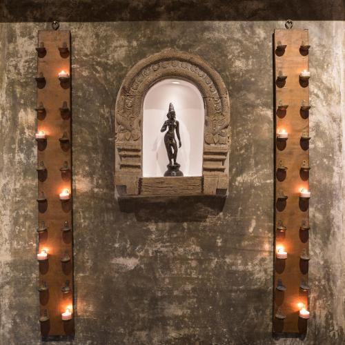 a statue in a niche in a wall with lights at Clingendael Hotel in Digana
