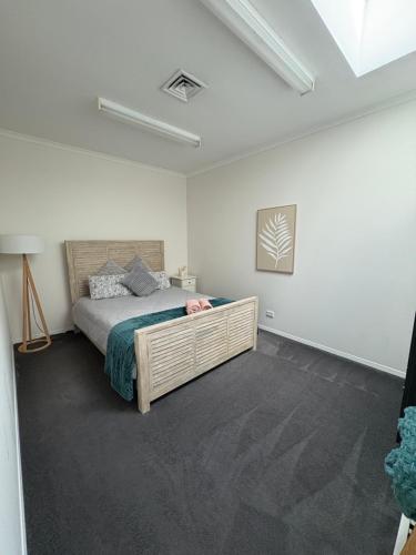 Un dormitorio con una cama en una habitación blanca. en Roantree House, en Portland