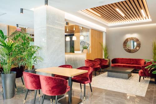 a restaurant with red chairs and a table and a couch at Salt Lake Hotel in Sovata