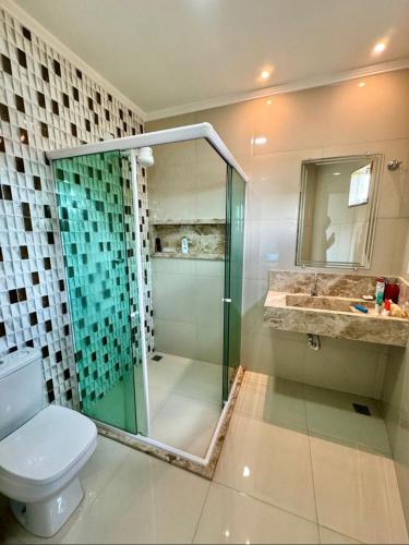 a bathroom with a shower and a toilet and a sink at Chalés do Abraão in Martins