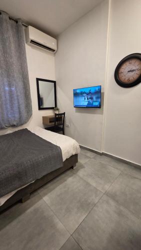 a bedroom with a bed and a clock on the wall at Ben Hillel Boutique Hotel in Jerusalem