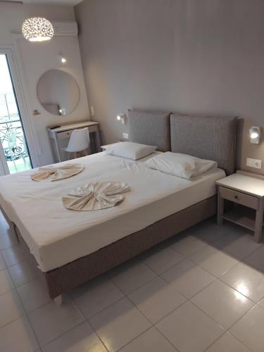 a bedroom with a large bed with two towels on it at Panorama in Pythagoreio