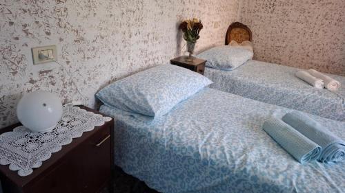 two twin beds in a room with a table at La Dimora di Beatrice in Santa Brigida