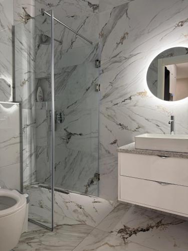 a bathroom with a shower and a toilet and a sink at Solèa Luxury Suites 