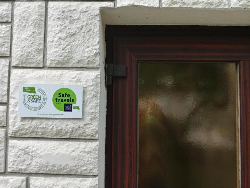 a sign on a brick wall next to a door at Hisa Taljat in Most na Soči