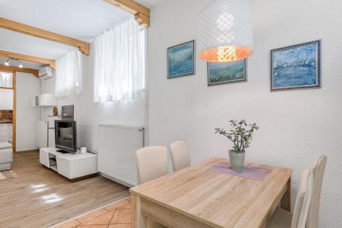 a dining room with a table and chairs and a television at Hisa Taljat in Most na Soči