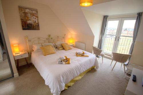 a bedroom with a large white bed with towels on it at Martello Sunrise - Luxury 3-bedroom Seaview Beach House in Felixstowe