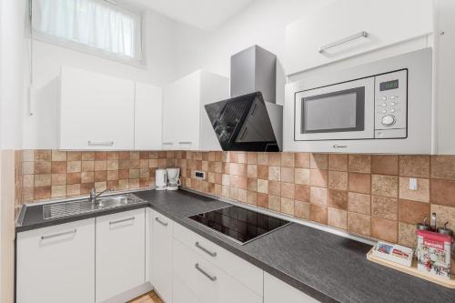 a kitchen with a sink and a microwave at Hisa Taljat in Most na Soči