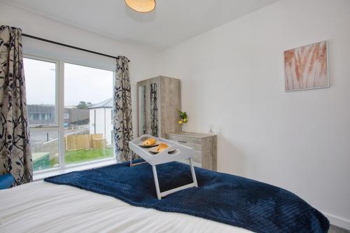 海尔New Harveys Yard By Signature Stays - New Hayle Luxury Stay - Walk to Beach - Sleeps 6的一间卧室配有一张床,并备有水果托盘