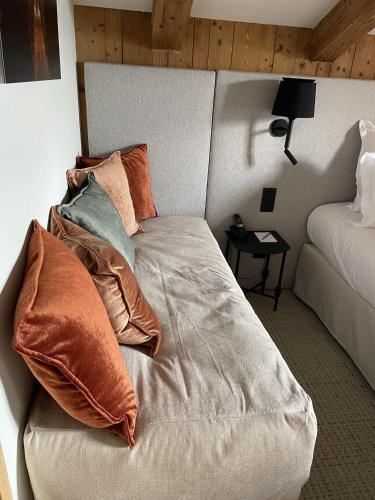 a bed with pillows on it in a bedroom at La Ferme du Golf in Megève