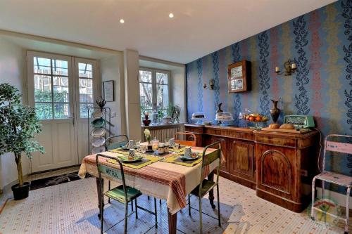 une salle à manger avec une table et une cuisine dans l'établissement La goutte d'or, à Combourg