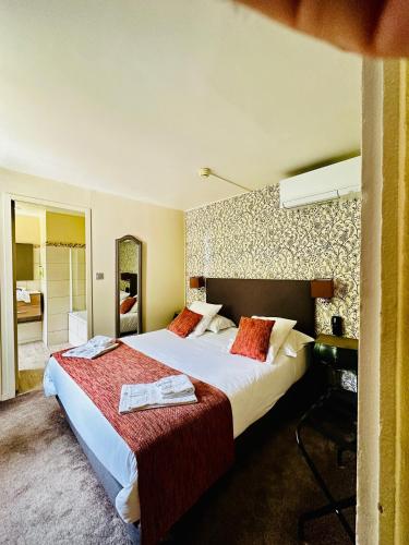 a hotel room with two beds and a bathroom at Hôtel Restaurant Le Repère in Vizille