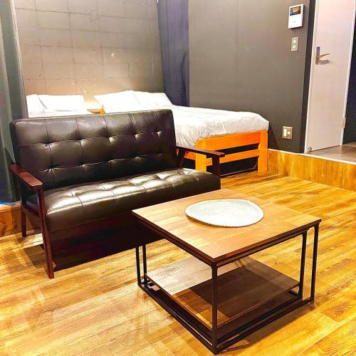 a living room with a couch and a coffee table at Kumamoto Serviced Apartment Sakura Mee 桜美 in Kumamoto